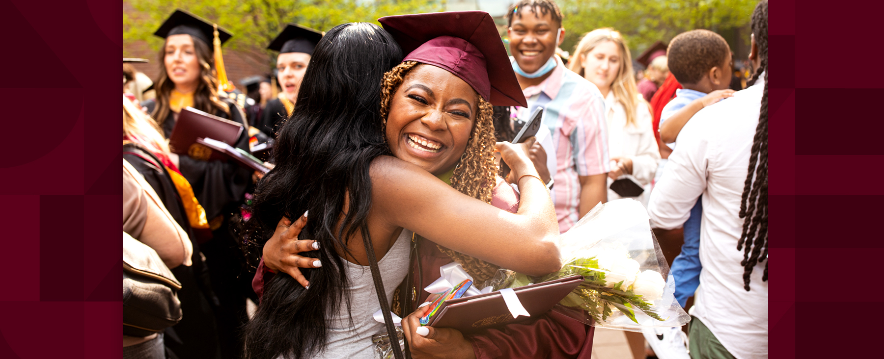 A Loyola University Chicago graduate receives a hug from a well wisher at Commencement 2023