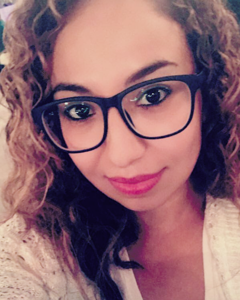 A woman with curly hair and glasses