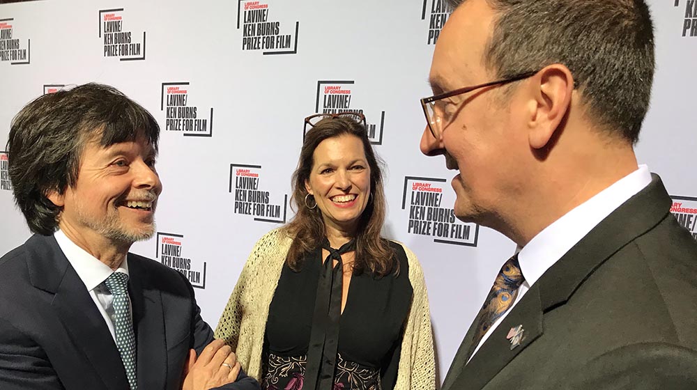 Elizabeth Coffman, center, an associate professor in the School of Communication at Loyola, and her co-director Mark Bosco, S.J., right, speak with legendary documentary filmmaker Ken Burns at the award presentation for the Library of Congress Lavine/Ken Burns Prize for Film. (Photo: Ted Hardin)