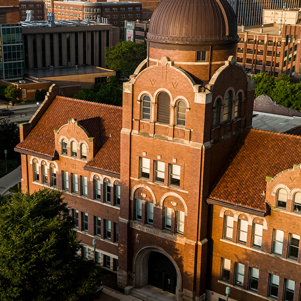 An aerial perspective of the copper-domed Dumbach building at golden hour on the Lake Shore campus.