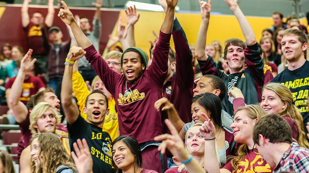 Loyola fans showing some school spirit and cheering at a sporting event.